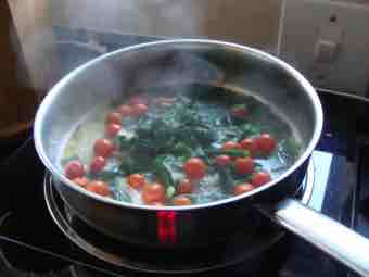 Eggs Florentine cooked with onions and red tomatoes and peppers.