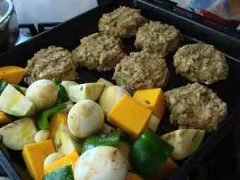 Fish cakes and roast vegetables on a baking tray. Fish cakes and roast vegetables on a baking tray.