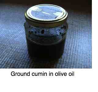 What is cumin, being stored under olive oil.