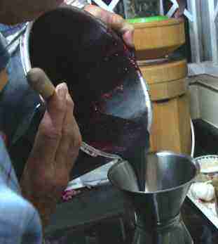 Bottling mulberry jam using a funnel Bottling mulberry jam using a funnel